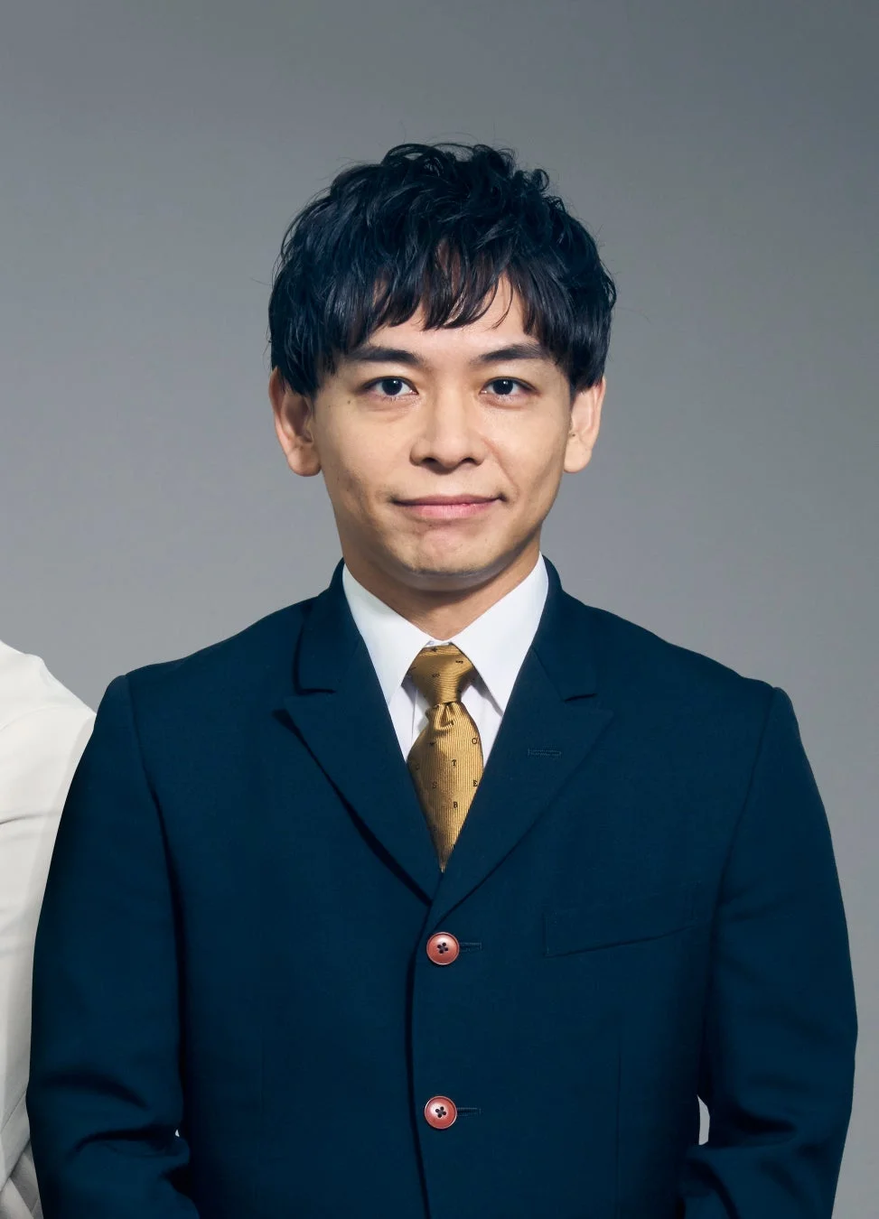 暗い色のスーツと金色のネクタイを着用した日本人男性のポートレート