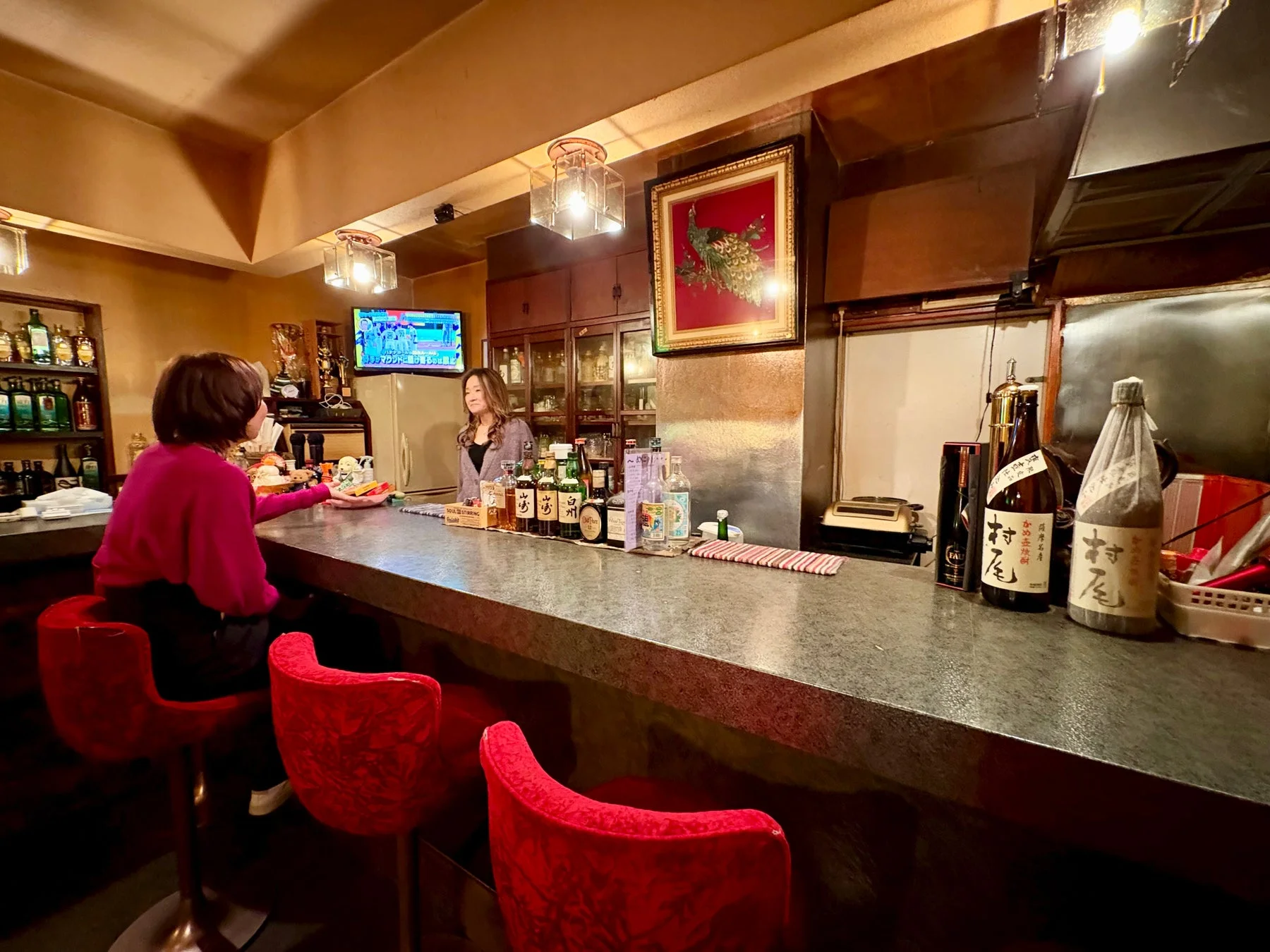 バーのカウンターでお客様が店員と向き合っている様子