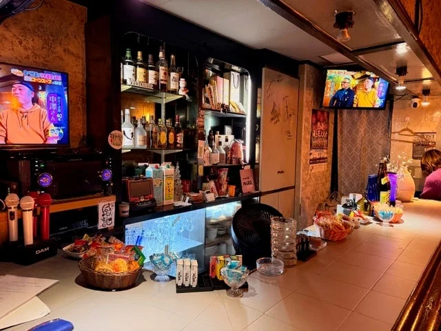 カラオケ設備が整った日本のバーまたはスナックバーの店内風景