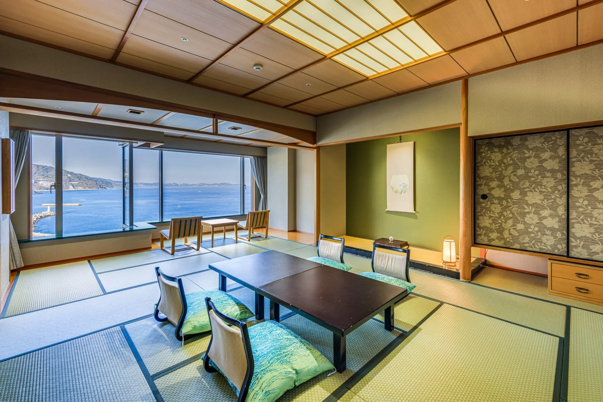 大きな窓から美しい海の景色を一望できる広々とした和室